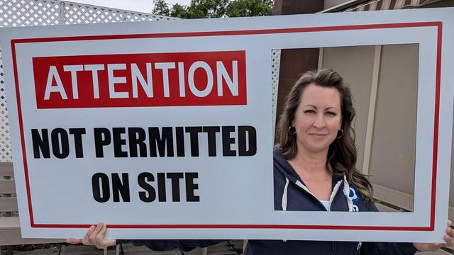 Dawn Armstrong from CUPE 3500 Holding the Not Permitted on Site Sign