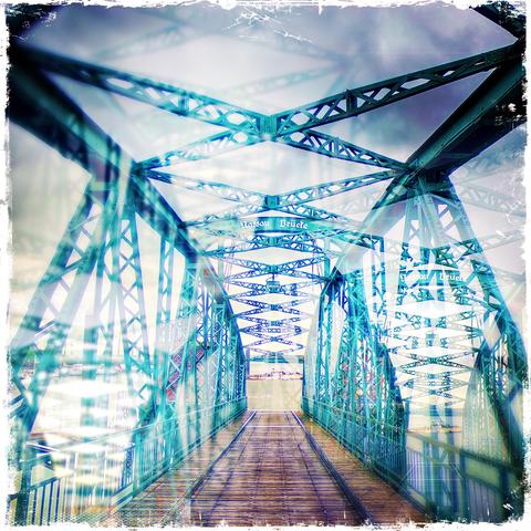 Multiple exposure of Wilhelmshaven‘s Nassau Bridge with green-painted metal struts and a floor made of dark brown wooden planks in a worn-out frame. 