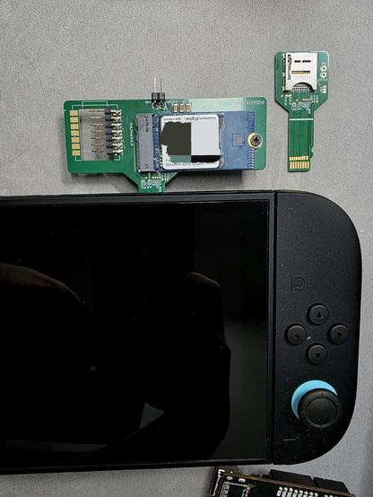A PCB adapter inserted into a Switch 2. On the adapter is a M.2 M-Key connector with an SSD inserted