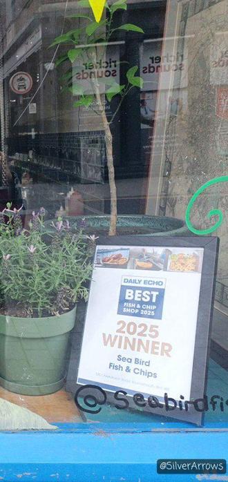 Sign in shop window showing 2025 winner of best fish and chip shop by Daily Echo