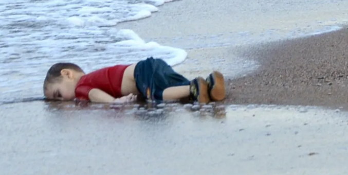 Zu sehen ist das Pressefoto des Jahres 2016 und zeigt das tote Kind Alan Kurdi am Strand liegend. 