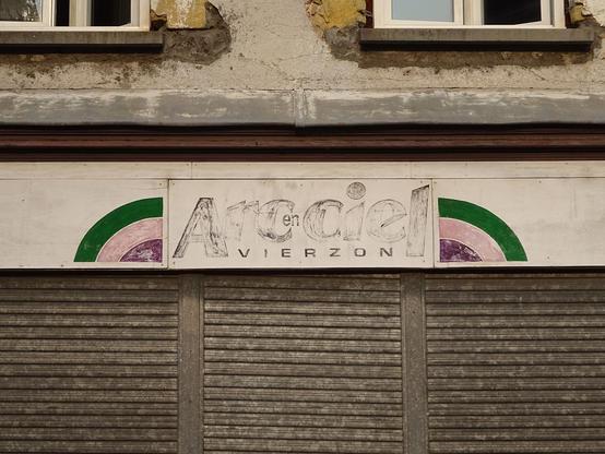 enseigne effacée Arc en ciel Vierzon avec un bout d'arc en ciel vert, rose et violet à gauche et un à droite.