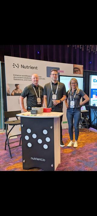 three smiling people at a tradeshow with Nutrient branding