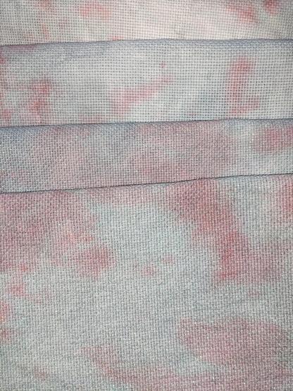 Fabric dyed with a light grey and a soft pink marbling.
