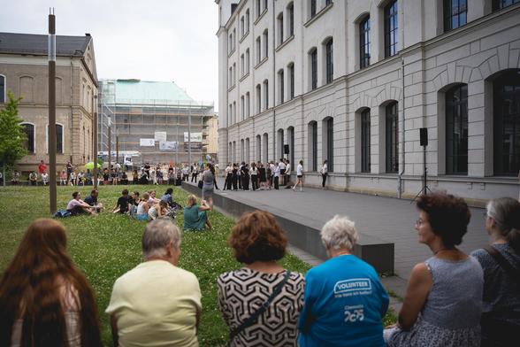 Rege Anteilnahme in den unterschiedlichsten Alterschichten säumen im Lesegarten der Universitätsbibliothek die zentrale Rasenfläche.