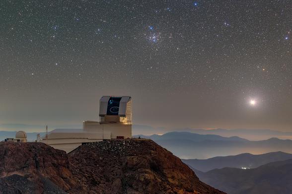 NSF–DOE Vera C. Rubin Observatory is seen with its dome open during First Look observation activities in April 2025. Messier 41, the Little Beehive Cluster, can be seen over the telescope in this telelens photo.

Image released June 23, 2025.