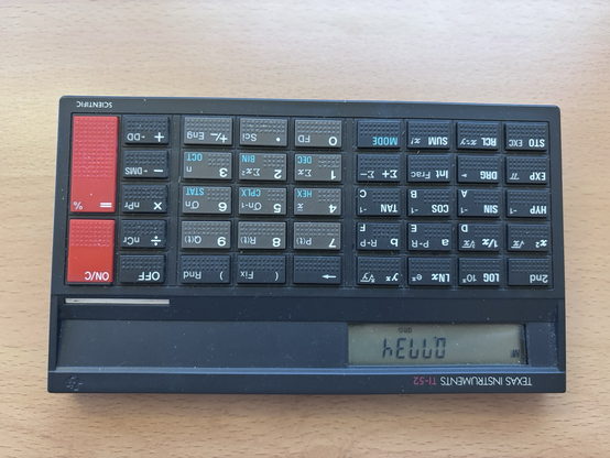 A Texas Instruments TI-52 scientific calculator from about 1985, turned upside down so it displays 0.7734 as hello