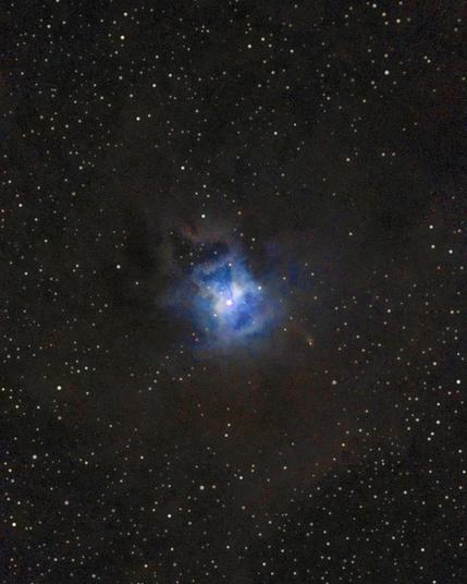 Photo of NGC 7023, the Iris Nebula, a bright reflection nebula in the constellation Cepheus, taken at Bubulcus & Bolotas. A brilliant blue glow surrounds a central star, with dark dust lanes and a star field in the background.