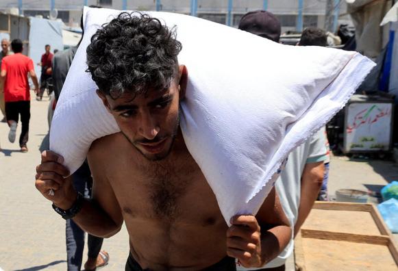 A bare-chested man carries a bag of flour on his shoulders.

Spiked with Oxycodone?