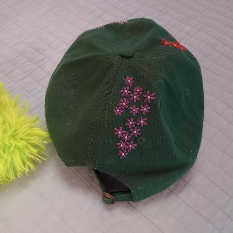 Here's a lovely photo of the back of the cap where we see a cluster of embroidered purple flowers.