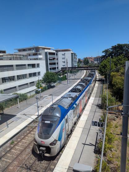 Un TER AuRa Regiolis quitte la gare de Thonon vers Évian. Grand ciel bleu.
