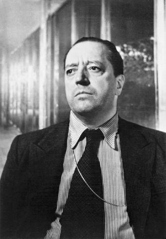Black and white image of Mies van der Rohe in a building.
