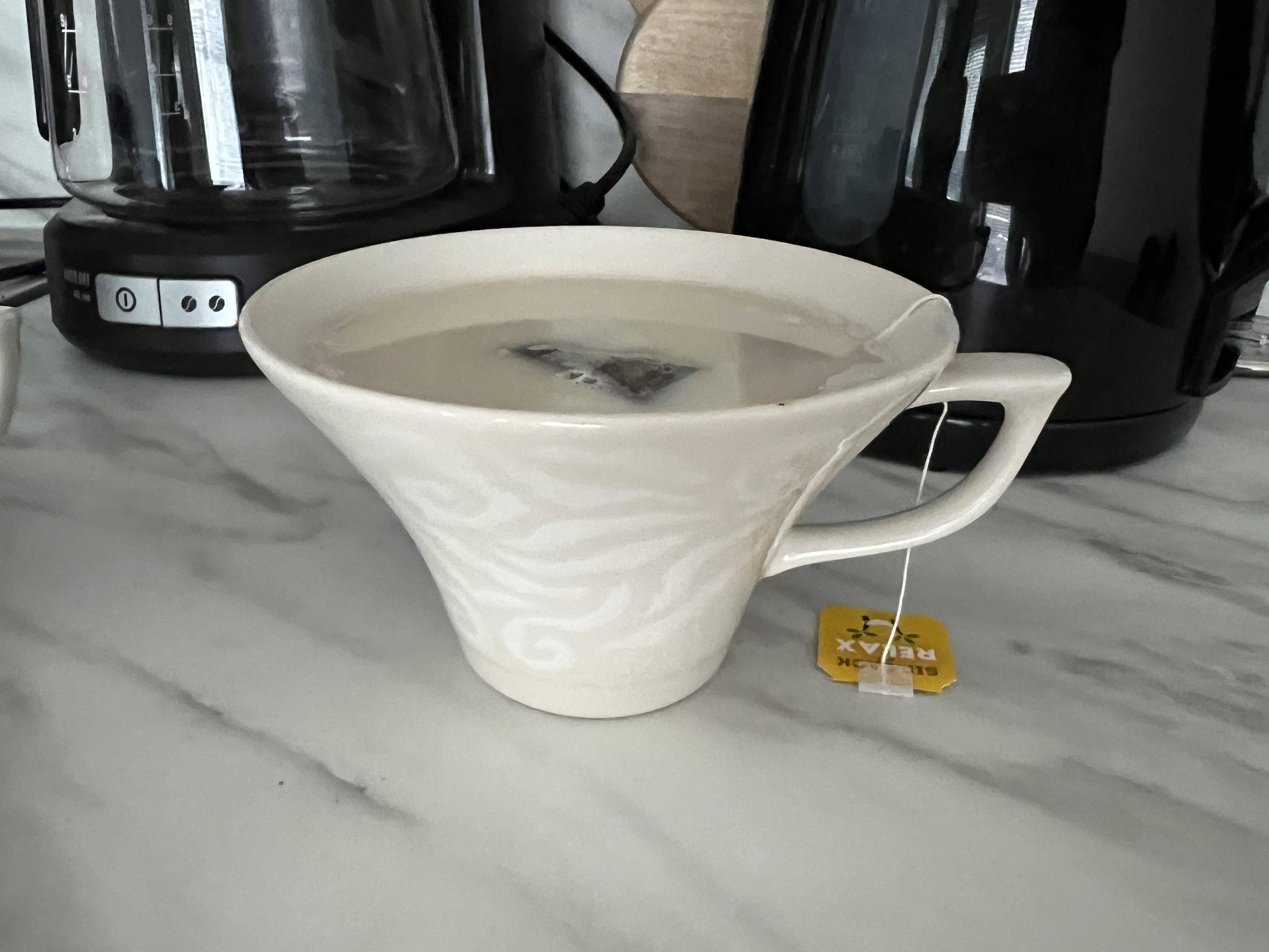 A designer cup with a very small base opening up towards the top ending with a very large diameter.