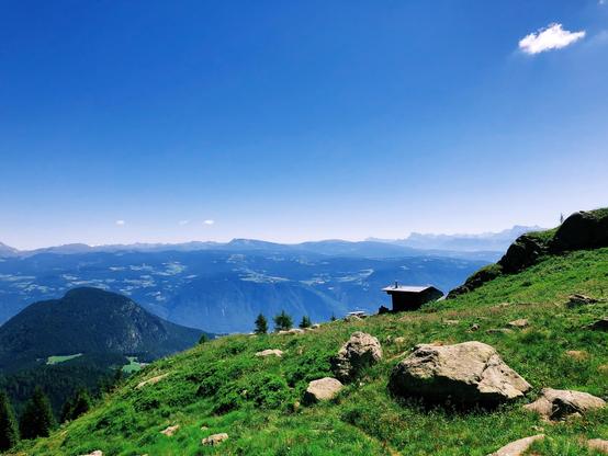 A tiny mountain hut and the peaks of the Dolomites in the distance