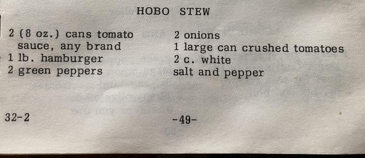 Photo of an old recipe book, specifically the recipe for “Hobo Stew.” It calls for: 2 (8 oz.) cans tomato sauce, any brand; 1 lb. hamburger; 2 green peppers; 2 onions; 1 large can crushed tomatoes; and 2 c. white salt and pepper.