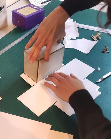 Montage du recouvrement auto-collant d'une boîte de jeux de société.