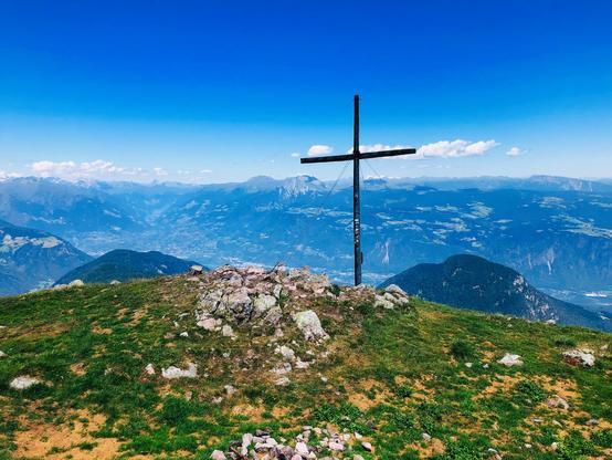 The cross at the summit of Mt. Kleiner Laugen. Below the valley and many mountain peaks in the distance