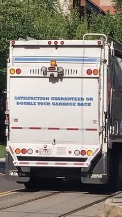 The back of a garbage truck. It says:

SATISFACTION GUARANTEED OR
DOUBLE YOUR GARBAGE BACK 