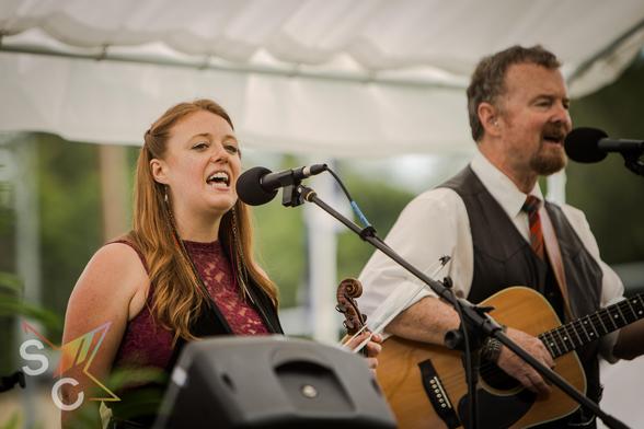 Katie Jane and Curt Ryan of the Katie Jane band singing and playing guitar at the Tacoma Highland Games