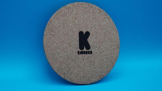 Runder Korkuntersetzer von hinten, mittig das gravierte Kindeko-Logo auf naturbelassenem Kork.