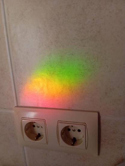 Reflejo del sol en un cristall de la terraza , se ven 3 colores en la pared de la cocina O 4 , rojo, naranja, amarillo y verde.