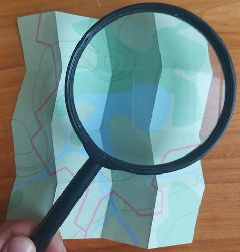 A map with a magnifying glass inspecting the map.