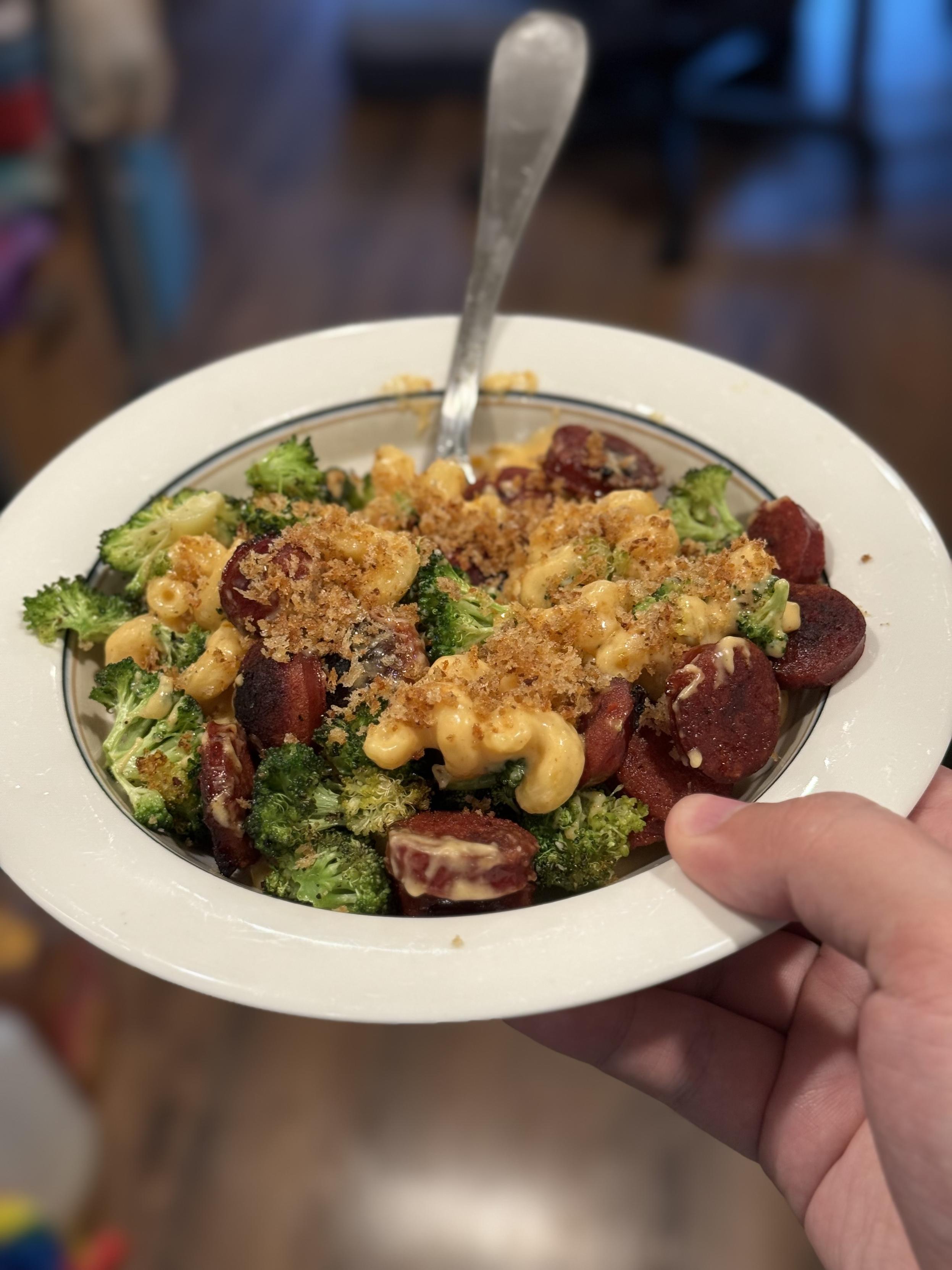 A bowl of the pasta in question, with bright green, yellow, and red from the broccoli, cheese, and sausage.