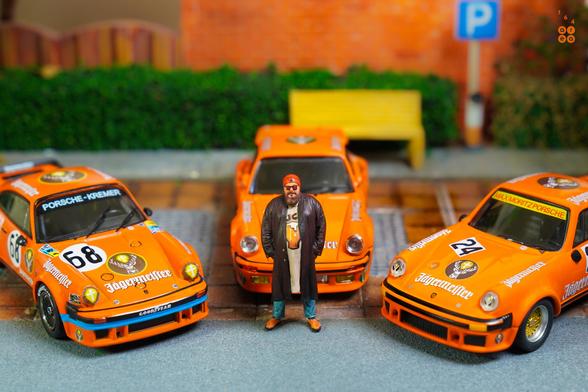A guy and three Porsche cars on Jägermeister livery in 1:64 scale with 1:64 figure on AREA 164