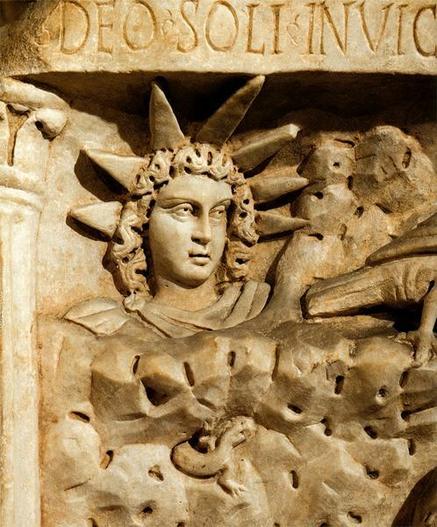 Relief of Sol, the Roman sun god. H has curly hair and wears a cloak pinned over his right shoulder. His head is crowned with a seven-spiked aureola. An inscription starting with "DEO SOLI INVICT..." can be read above the relief.