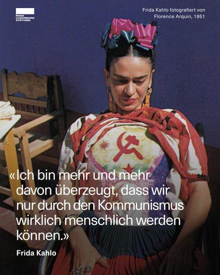 Fotografie von Frida Kahlo aus dem Jahr 1951, aufgenommen von Florence Arquin. Sie sitzt in der Sonne, trägt ein traditionelles mexikanisches Kleid mit einem großen kommunistischen Symbol (Hammer und Sichel) auf der Brust. Im Bild ist ein Zitat von ihr eingeblendet: ‚Ich bin mehr und mehr davon überzeugt, dass wir nur durch den Kommunismus wirklich menschlich werden können.‘