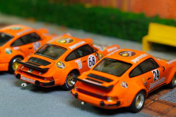 A rear side of three Porsche cars on Jägermeister livery in 1:64 scale on AREA 164