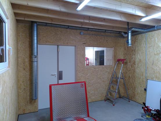 Shop picture showing white double doors a window and new ducting for the fume extraction system.