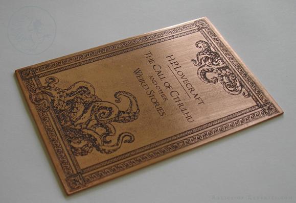 A copper plate is etched with an illustration showing two sets of tentacles overshooting an elaborate frame. Inbetween the two sets of tentacles, the plate reads "H.P. Lovecraft, The Call of Cthulhu and other Weird Stories".