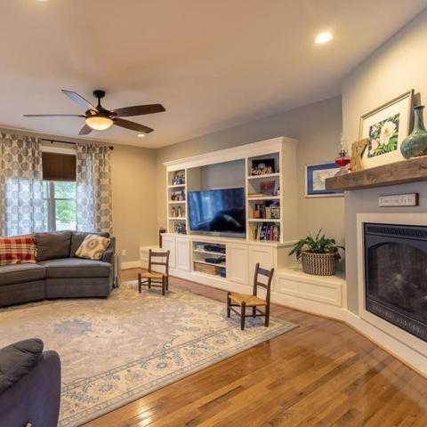 living room with wood floors, fireplace, and tv