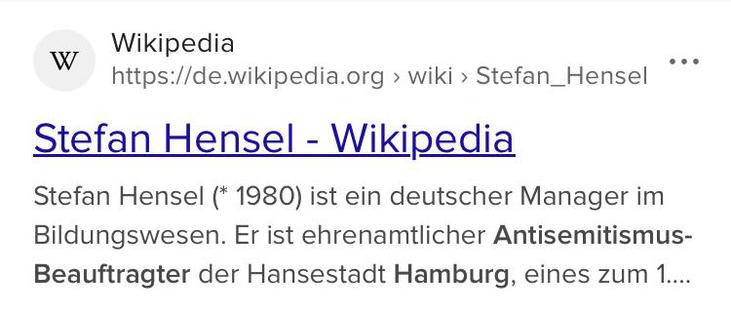 Das Bild zeigt einen Screenshot einer Wikipedia-Seite über Stefan Hensel. Oben links ist das Logo von Wikipedia mit einem "W" zu sehen, gefolgt von dem Namen "Wikipedia" und der URL "https://de.wikipedia.org/wiki/Stefan_Hensel". Der Titel der Seite lautet "Stefan Hensel - Wikipedia" und ist blau und unterstrichen. Darunter steht eine kurze Beschreibung: "Stefan Hensel (* 1980) ist ein deutscher Manager im Bildungswesen. Er ist ehrenamtlicher Antisemitismus-Beauftragter der Hansestadt Hamburg, eines zum 1..."