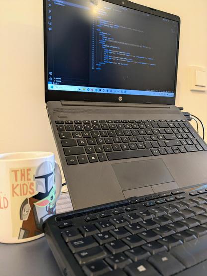 Laptop on the desk with a coffee cup, perfect for programming.