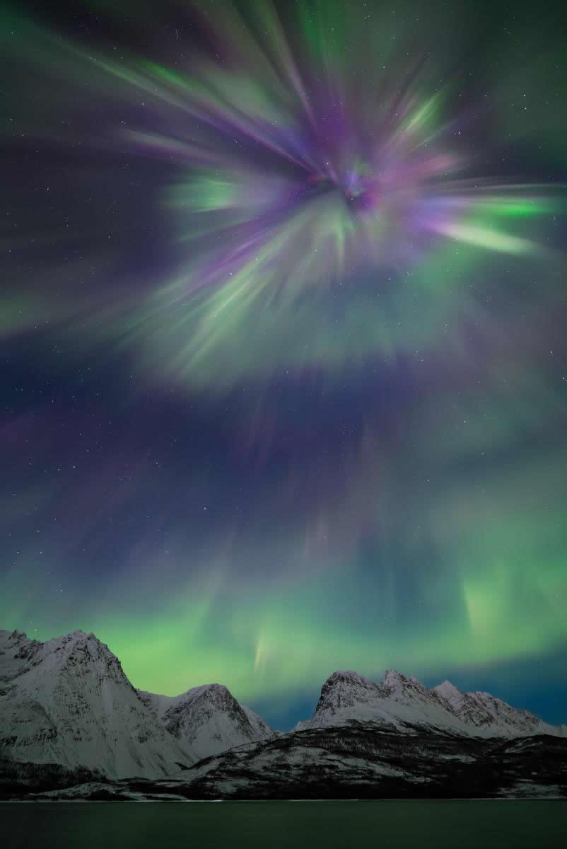 Purple-green aurora outburst over barren mountains. Purple-green aurora outburst over barren mountains.