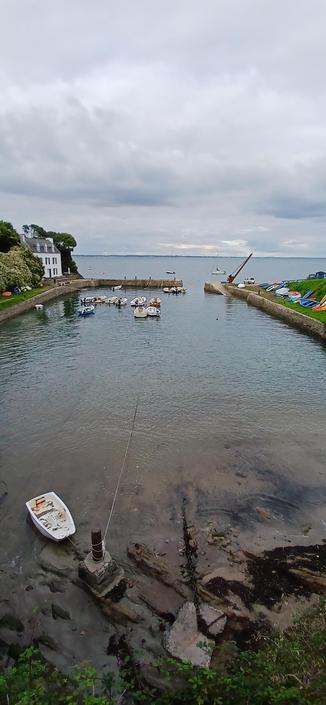 Port Lay, Ile de Groix, par temps nuageux à marée haute, vue de l'arrière dans la longueur, avec petits bateaux de pêche au mouillage.