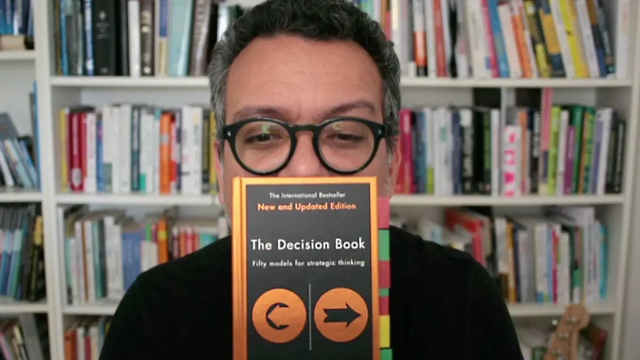 A picture of the author of this post holding the book “The Decision Book” in front of his face.