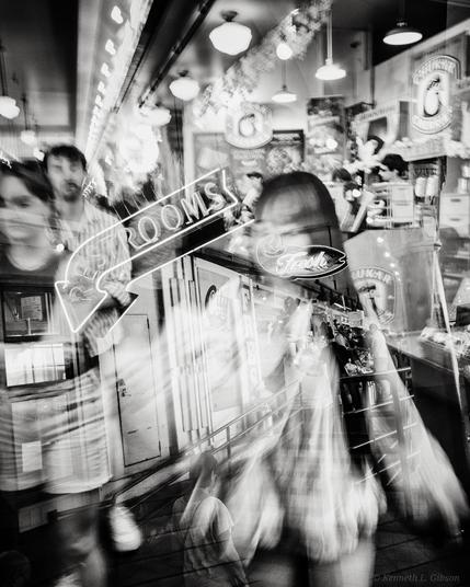 Black and white ICM double exposure photo of people with neon signs
