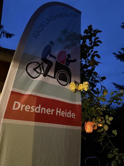 Unsere Radelflagge bei einem kleinen Sommerfest bei stimmungsvoller Beleuchtung im Garten am Rosenspalier.