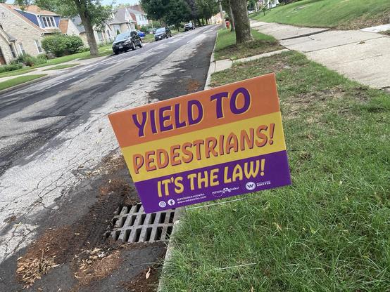 A sign that says “Yield to Pedestrians! It’s the law!”
