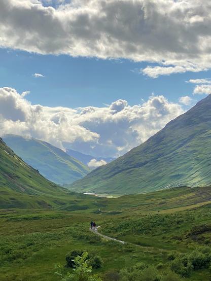 Two lovers walking through a majestic valley between mountains