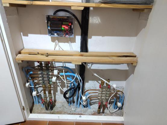 My central heating control cabinet.

Photo shows 2 shelves with piping coming from underground, and being distributed to heating circuits.

Each of the 9 distribution circuits has a WATTS 22C 24NA4 thermal expansion valve attached.

Each valve is attached to a central Kincony T16M controller (ESPHome driven), in a splash-resistant enclosure 

Power is provided by an RCD+24V DC transformer.