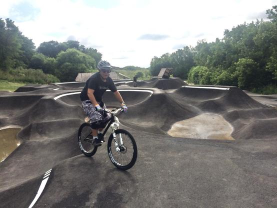 A guy riding a bike on a pump track.