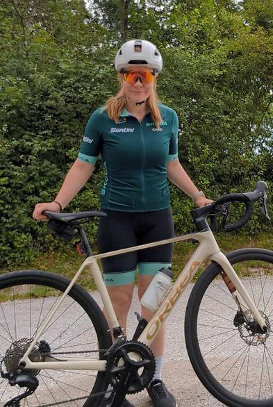 Ich in grüner Skoda-TdF-Radmontur, mein Rennrad vor mir haltend.