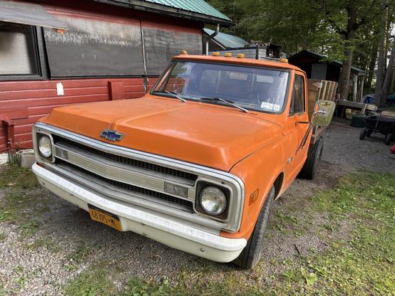 Orange truck with white grille and blue Chevy logo and orange lights on top