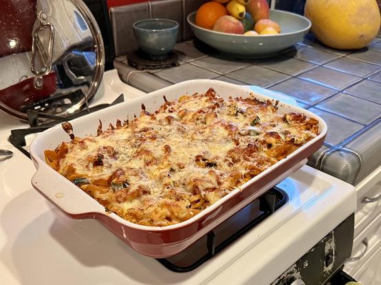 Yummy homemade baked ziti cooling on a stove stop