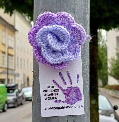 a purple knitted rose in the city of Salzburg, Austria. Stop Violence Against Women