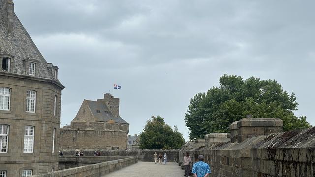 Auf dem Rundweg auf den Stadtmauern. Blick auf das Chateau mit Flagge.